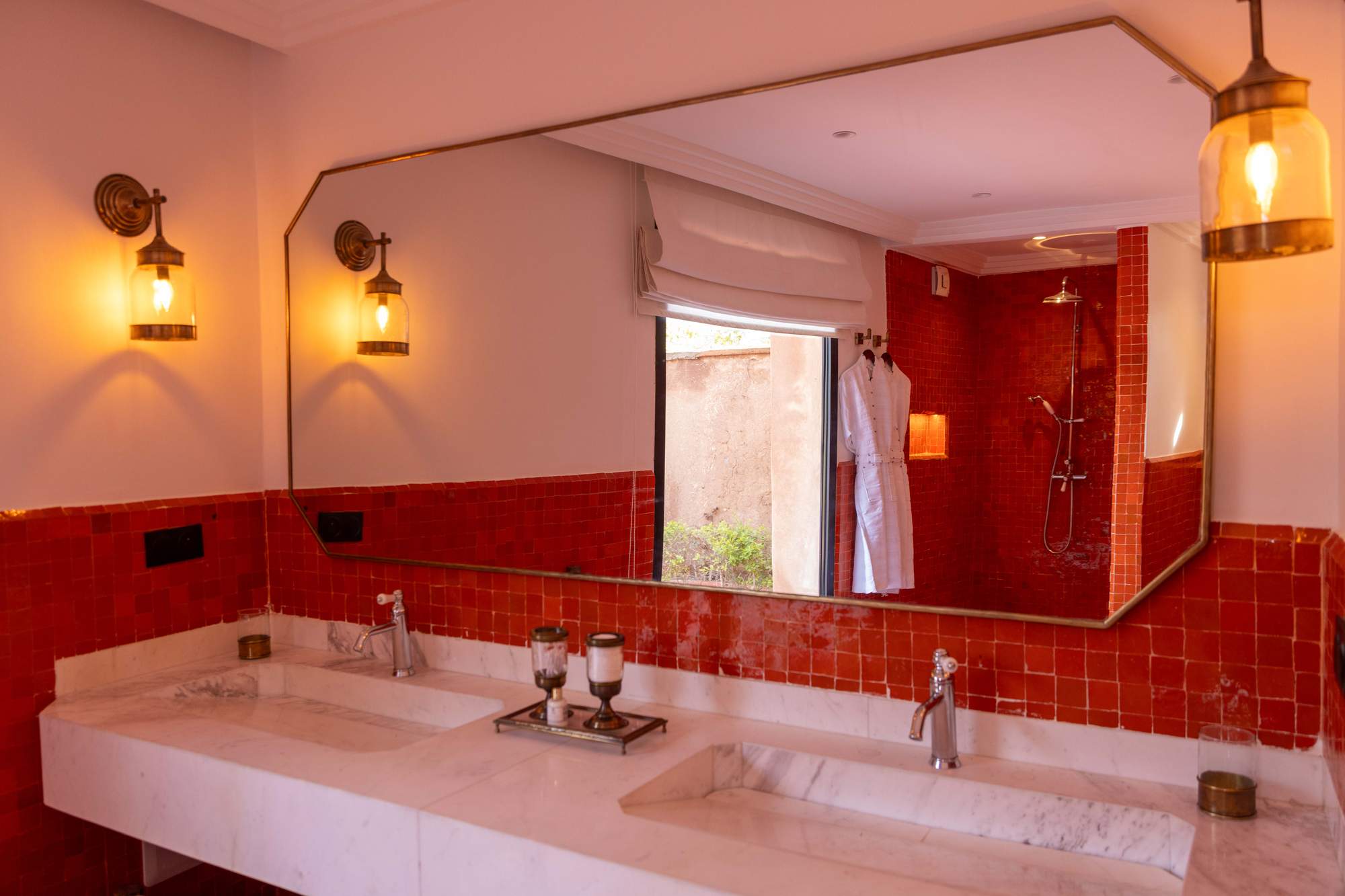 Suite Imi Ouaddar de la Villa Yemna à Marrakech, salle de bain avec double vasque et miroir rouge.