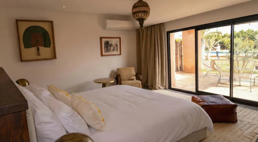 Suite Moulay Bouazza de la Villa Yemna à Marrakech, chambre avec lit, baie vitrée et vue sur la terrasse.