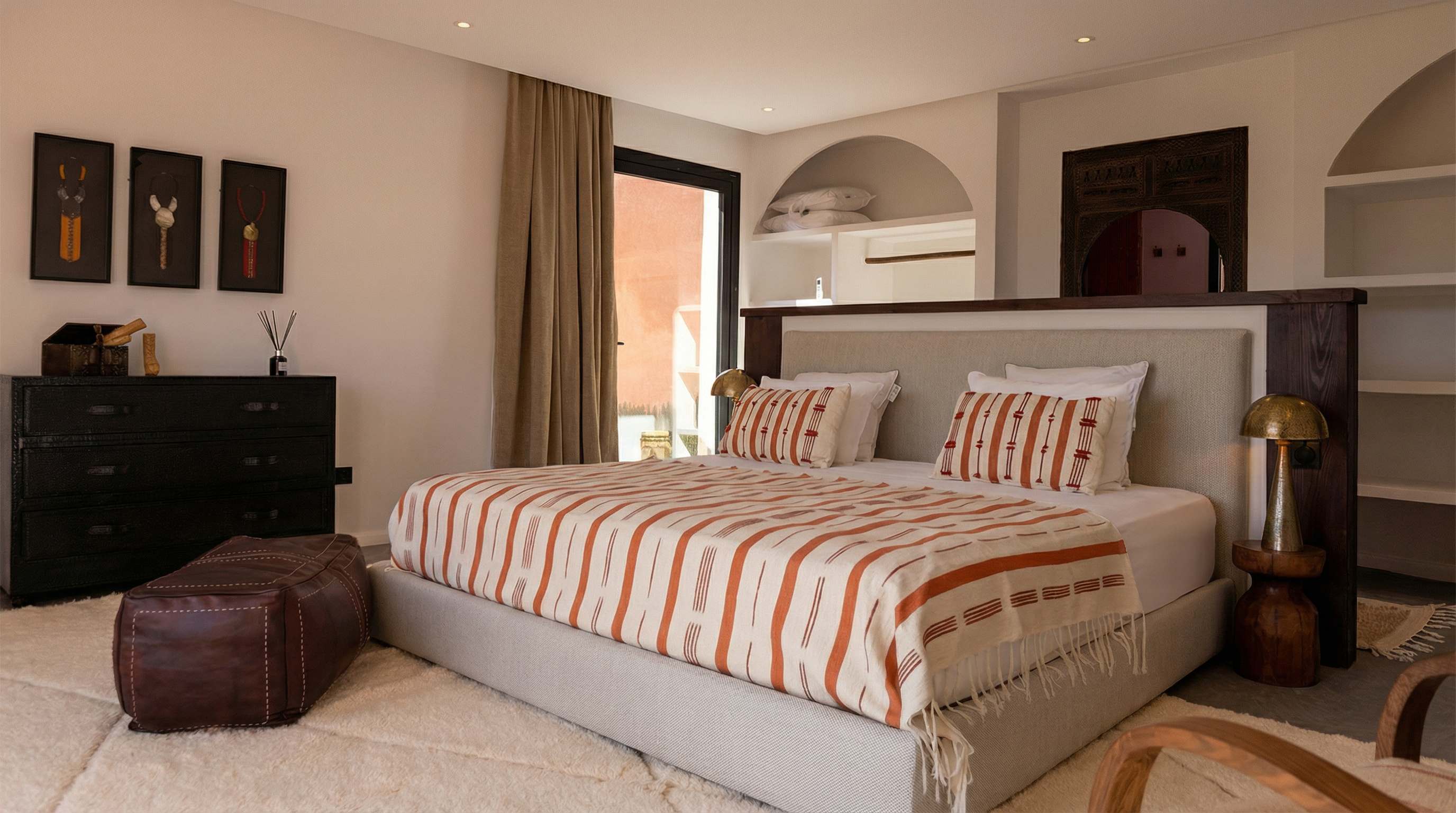 Suite Ourika de la Villa Yemna à Marrakech, chambre avec lit double et commode bronze, vue latérale.