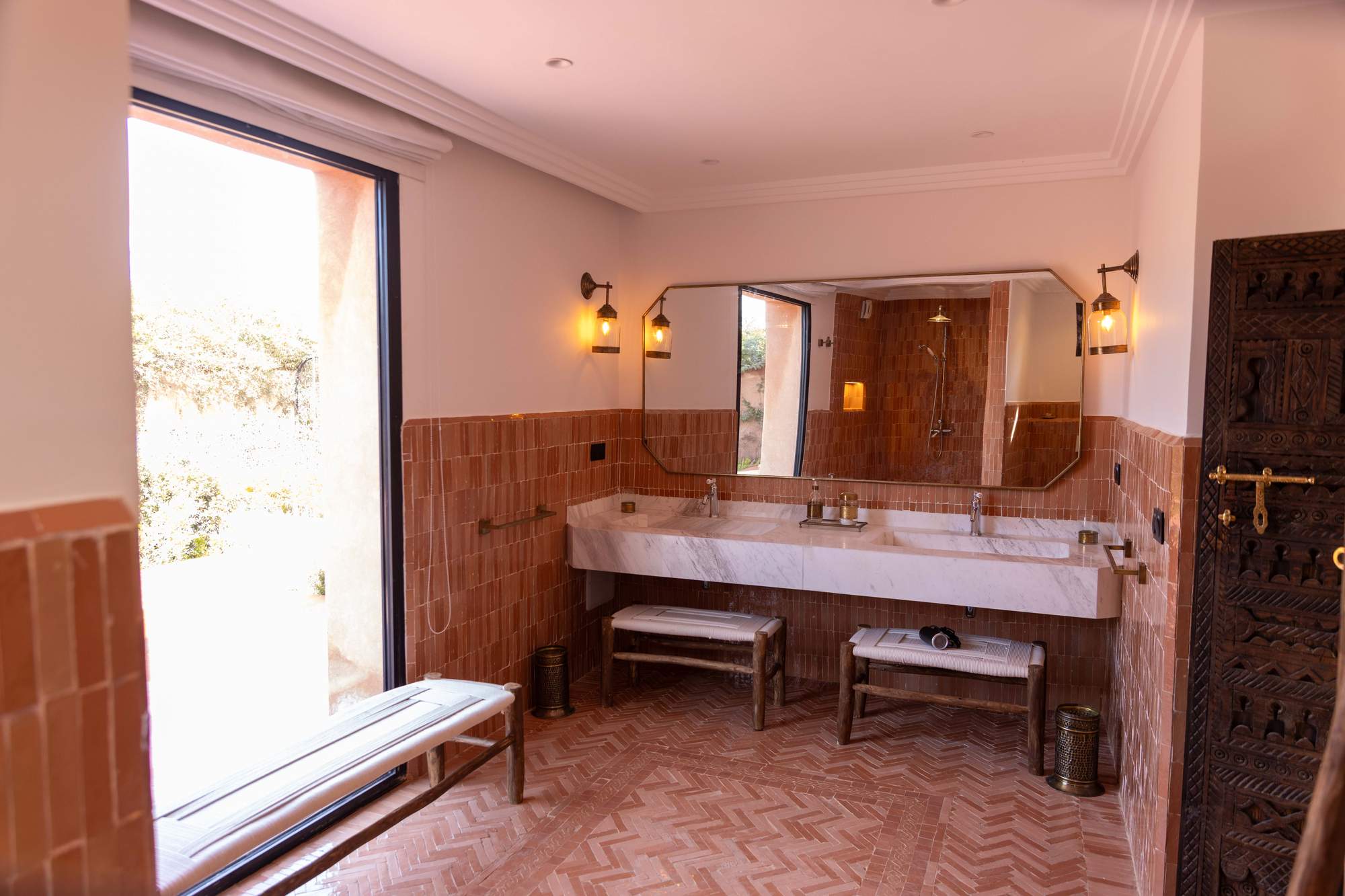 Suite Ourika de la Villa Yemna à Marrakech, salle de bain avec lavabo et miroir angulaire, vue extérieure.